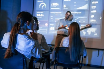 Líder de equipe conduzindo um planejamento de treinamento para seus funcionários, apresentando um plano de negócios em um projetor durante uma master class no escritório.
